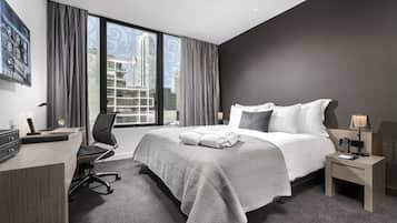 Una habitación de hotel moderna con una cama grande, un escritorio y una silla.
