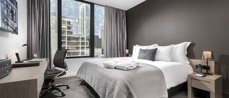 Ein modernes Hotelzimmer mit einem großen Bett, einem Schreibtisch und einem Stuhl.