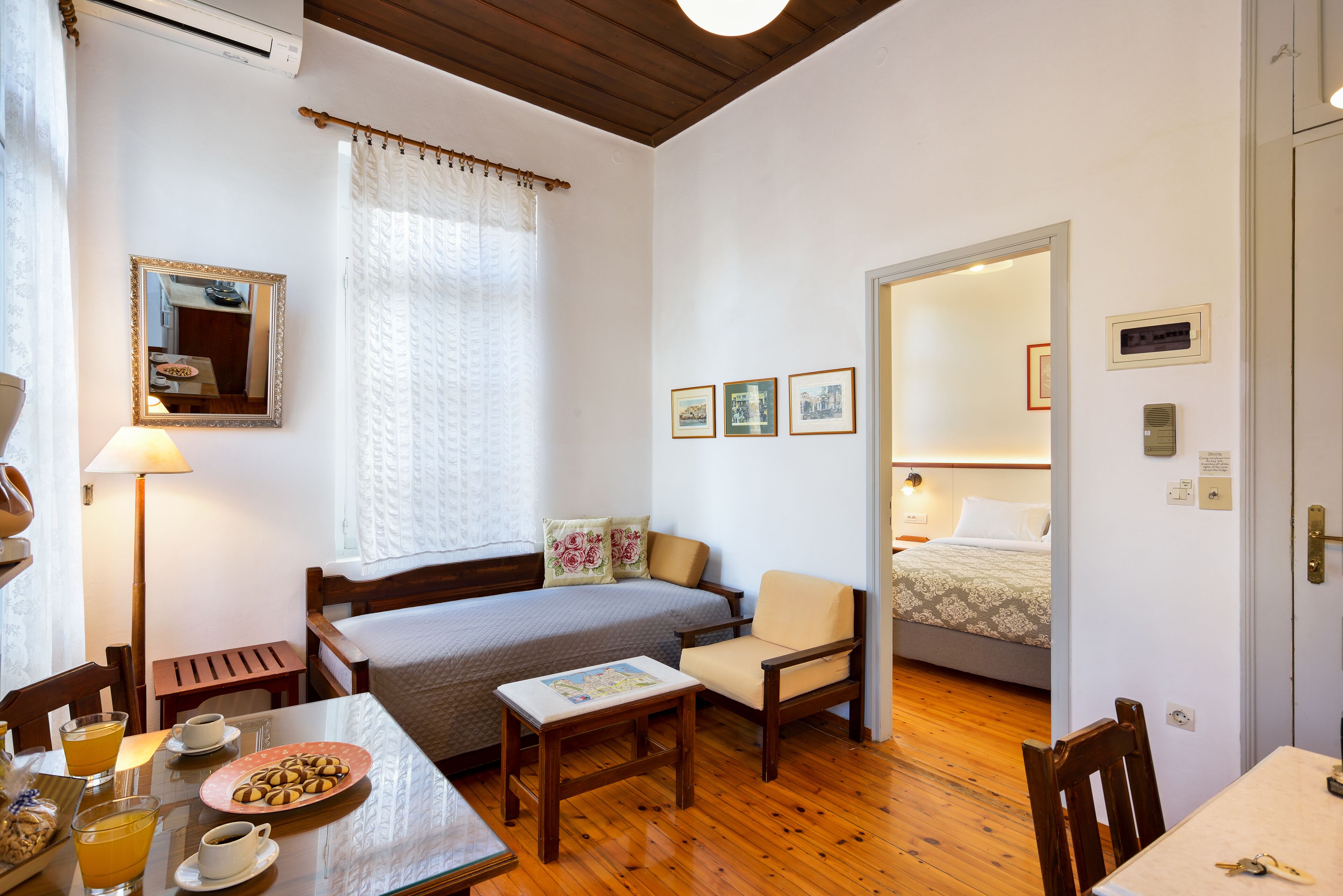 Una habitación acogedora con cama, una silla, una mesa con desayuno y un espejo.