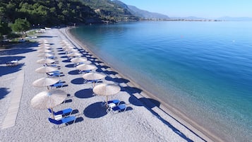 Vlak bij het strand, ligstoelen aan het strand, parasols, een strandbar