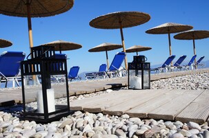 Una playa cerca, sillas reclinables de playa, sombrillas