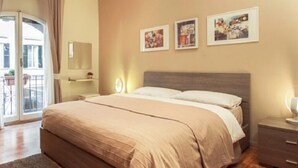 A bedroom with a large bed, a nightstand, a dresser, and a sliding glass door leading to a balcony. - B&B Cult Roma (Rome)