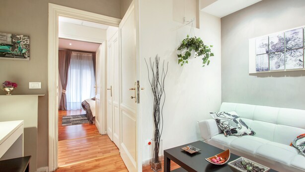 A modern living room with a sofa, a coffee table, and a vase with branches. - B&B Cult Roma (Rome)