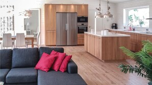 Une cuisine moderne avec des meubles en bois, des appareils électroménagers en acier inoxydable et un îlot central.