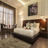 Quarto de hotel moderno com uma cama grande, uma escrivaninha e uma cadeira.