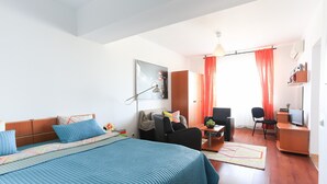 Une chambre d’hôtel moderne équipée d’un grand lit, d’un bureau, d’une chaise et d’un téléviseur.