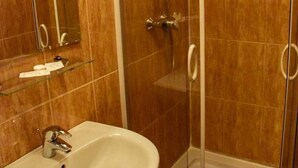 Uma casa de banho com lavatório, espelho e cabine de duche.
