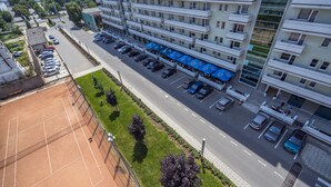 Un hôtel à plusieurs étages doté d’un parking, d’un espace extérieur aménagé et d’un court de tennis.