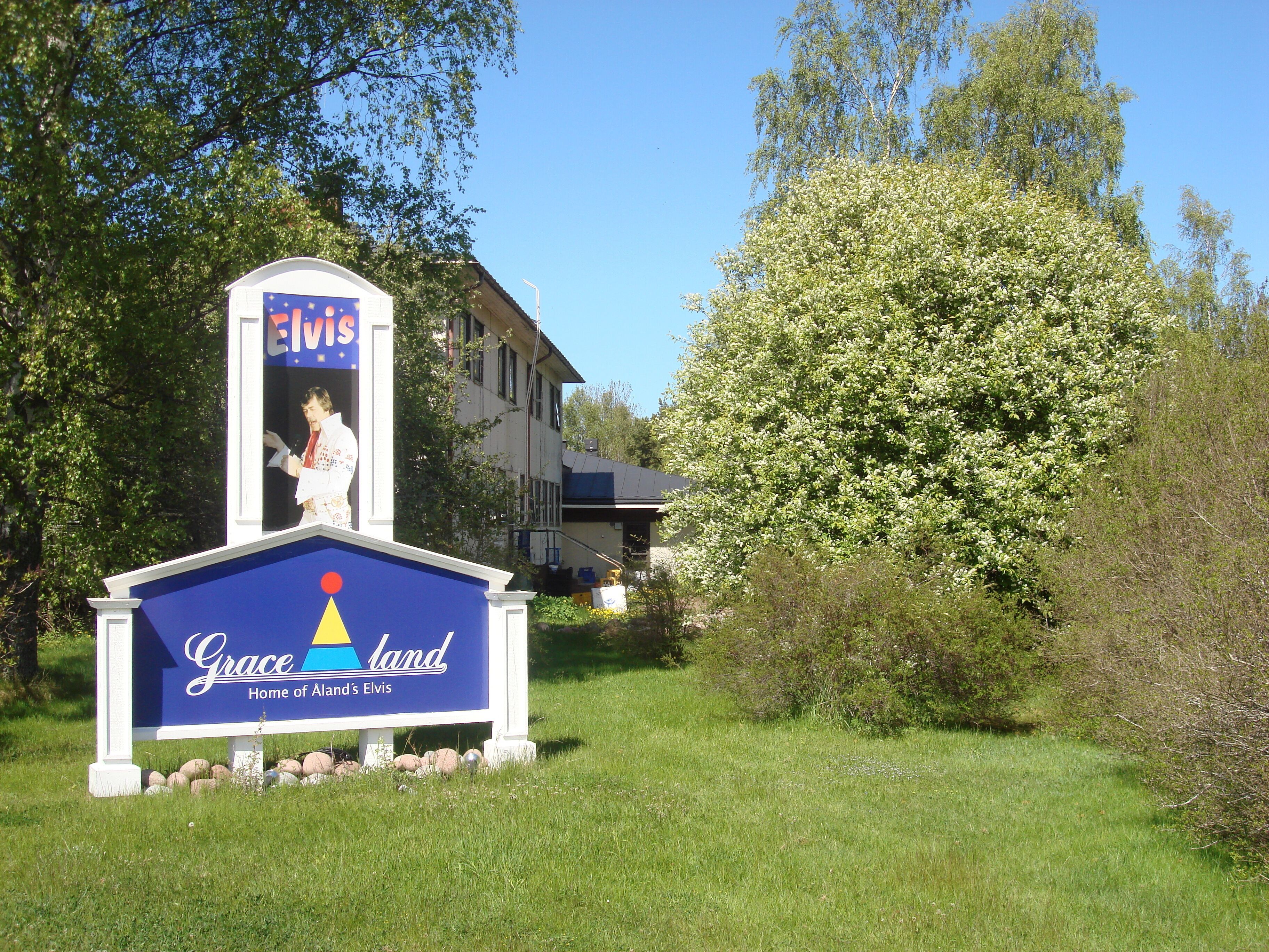 A sign for 'Grace Land' with a depiction of Elvis Presley.