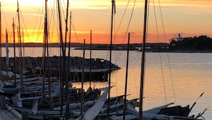 Un puerto deportivo con barcos amarrados a muelles de madera al atardecer.