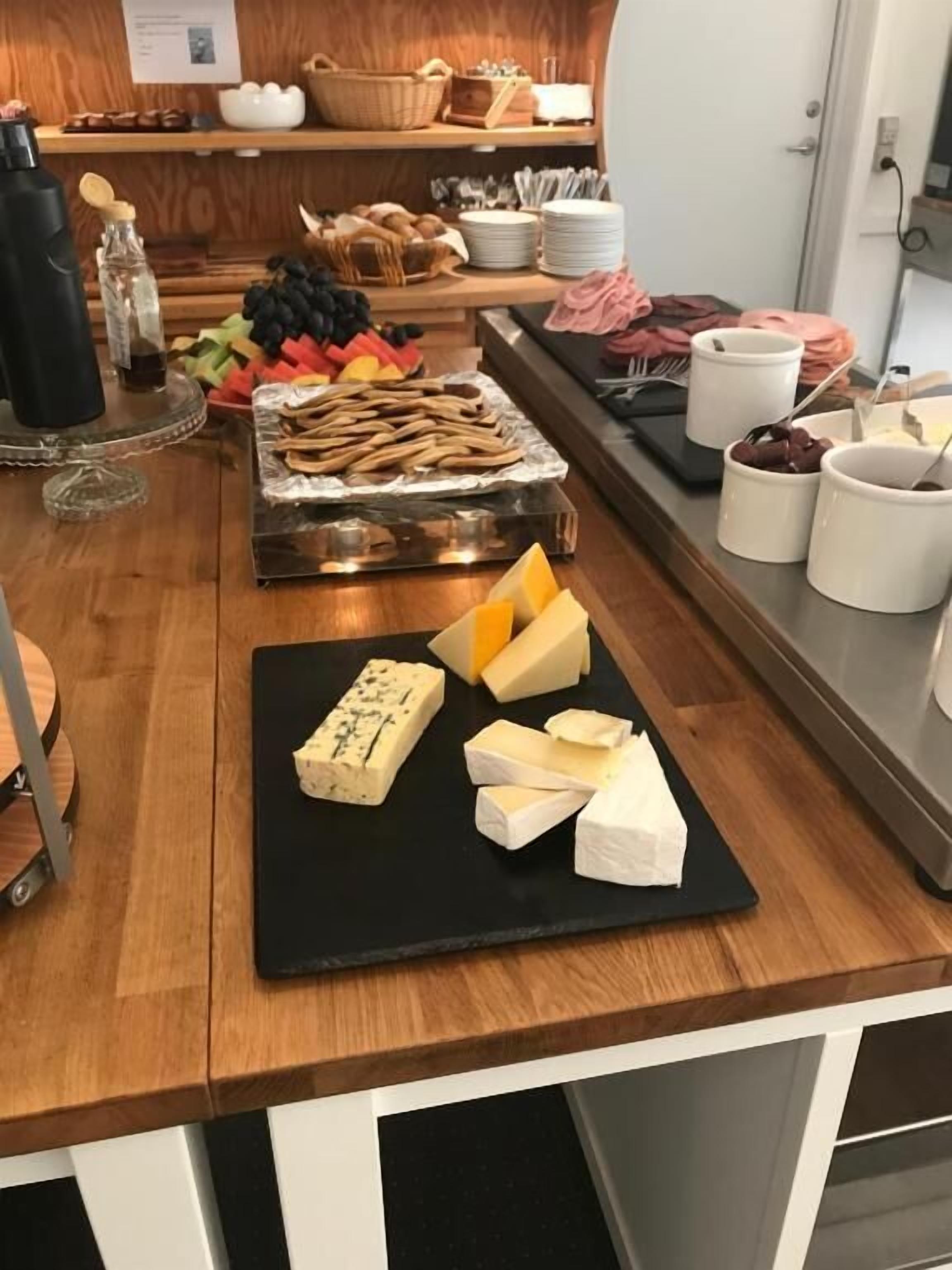 En buffet med forskellige oste, frugter og brød.