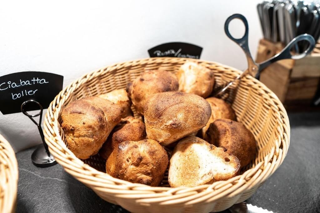 Una cesta de bollos de pan crabcotta con un cartel que indica el tipo.