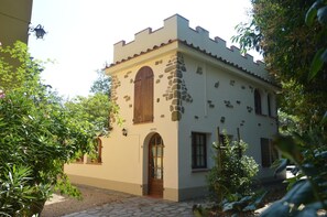A traditional building with a stone facade, a wooden door, and arched windows. - Podere San Lorenzo (Terranuova Bracciolini)