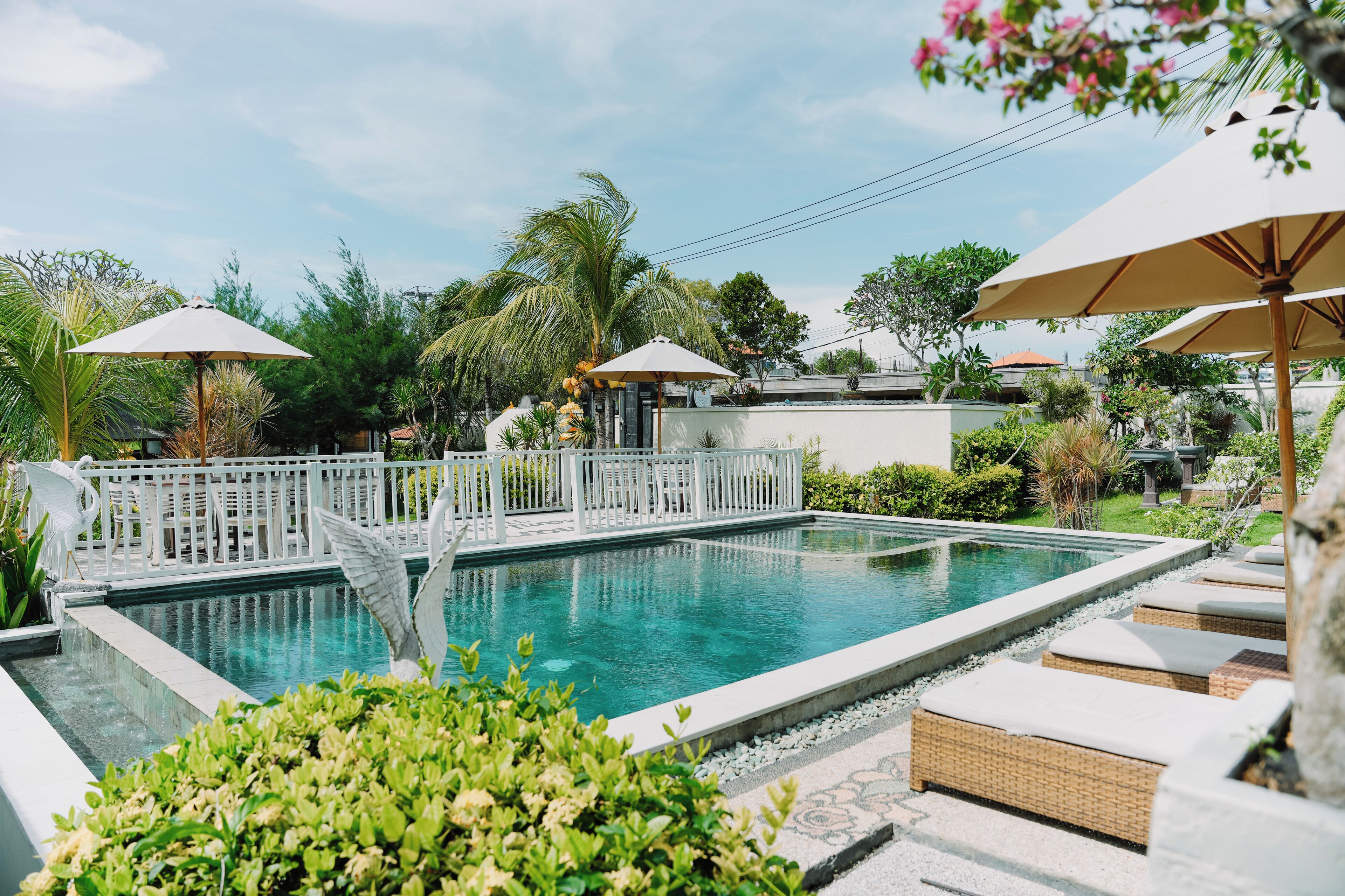 Una piscina al aire libre, sillones reclinables de piscina