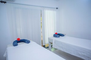A hotel room with two single beds, white bedding, and a window with sheer curtains. - Sky & Sand Zanzibar (Matemwe)