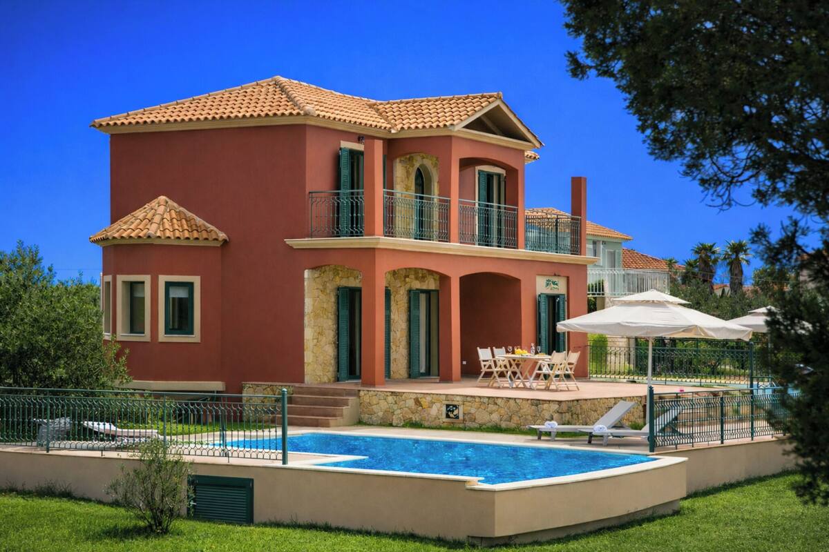 A two-story house with a swimming pool, outdoor seating, and a balcony.
