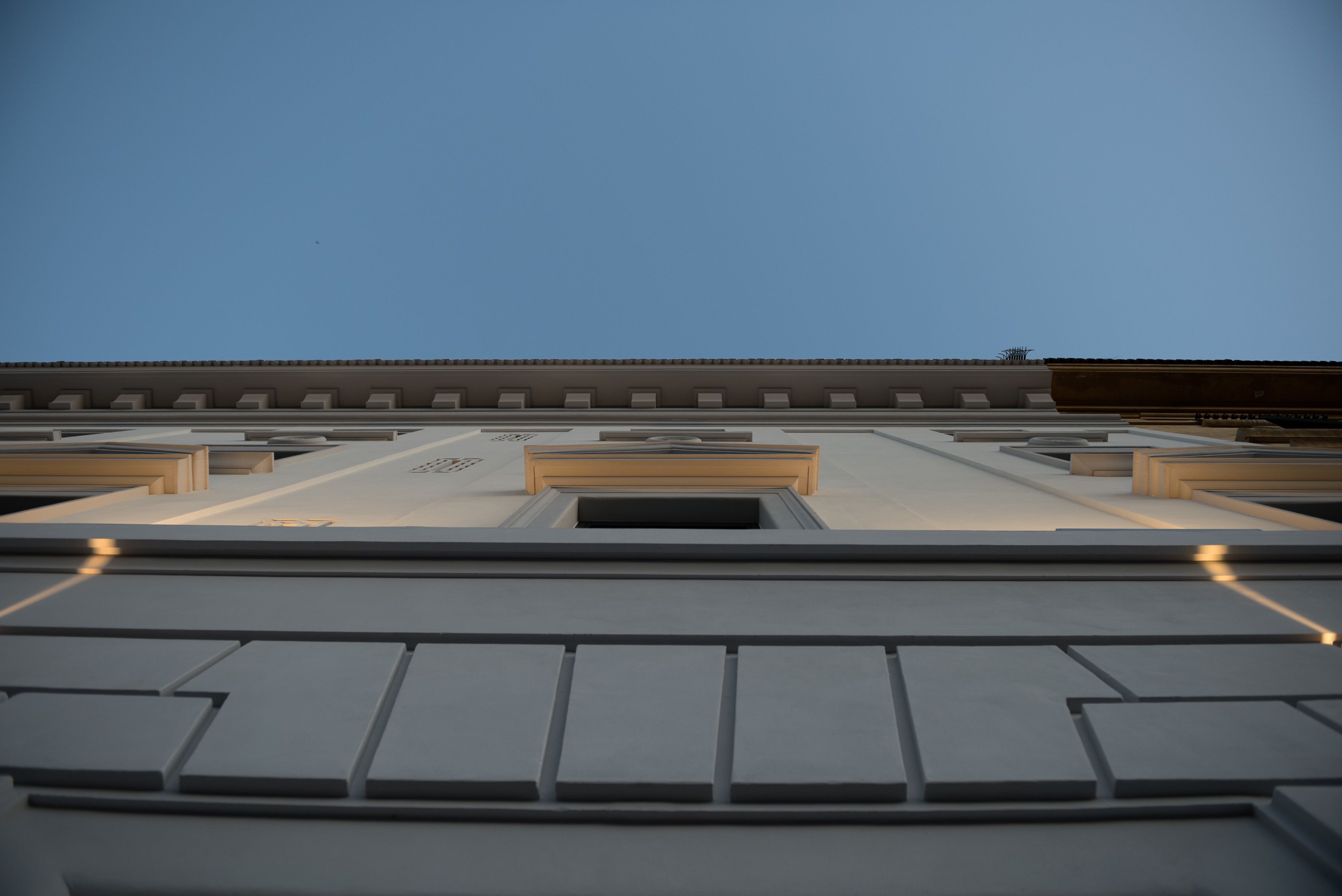 A modern building with a flat roof and a series of rectangular windows.
