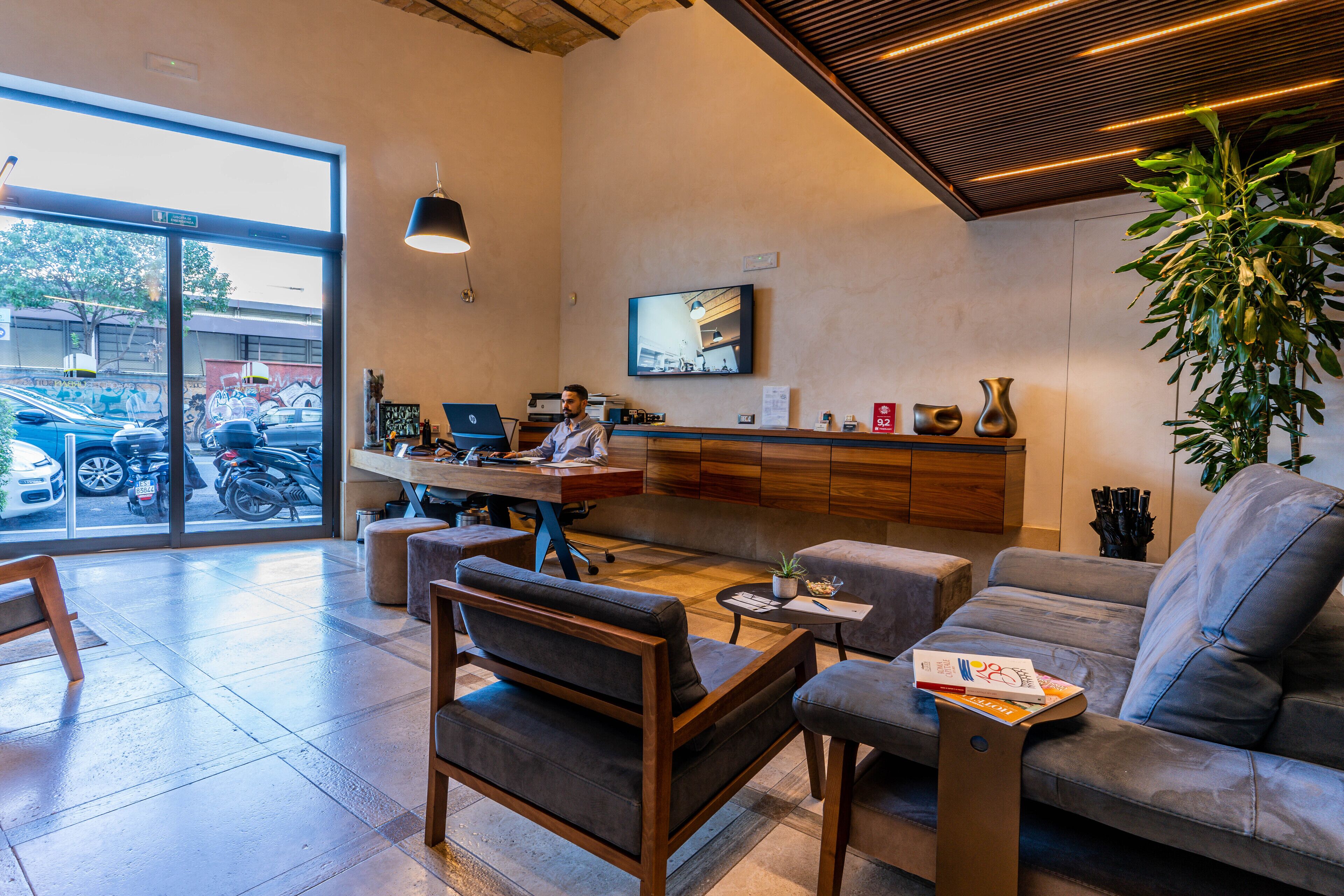 A modern interior with a sofa, armchairs, a coffee table, and a TV mounted on the wall.
