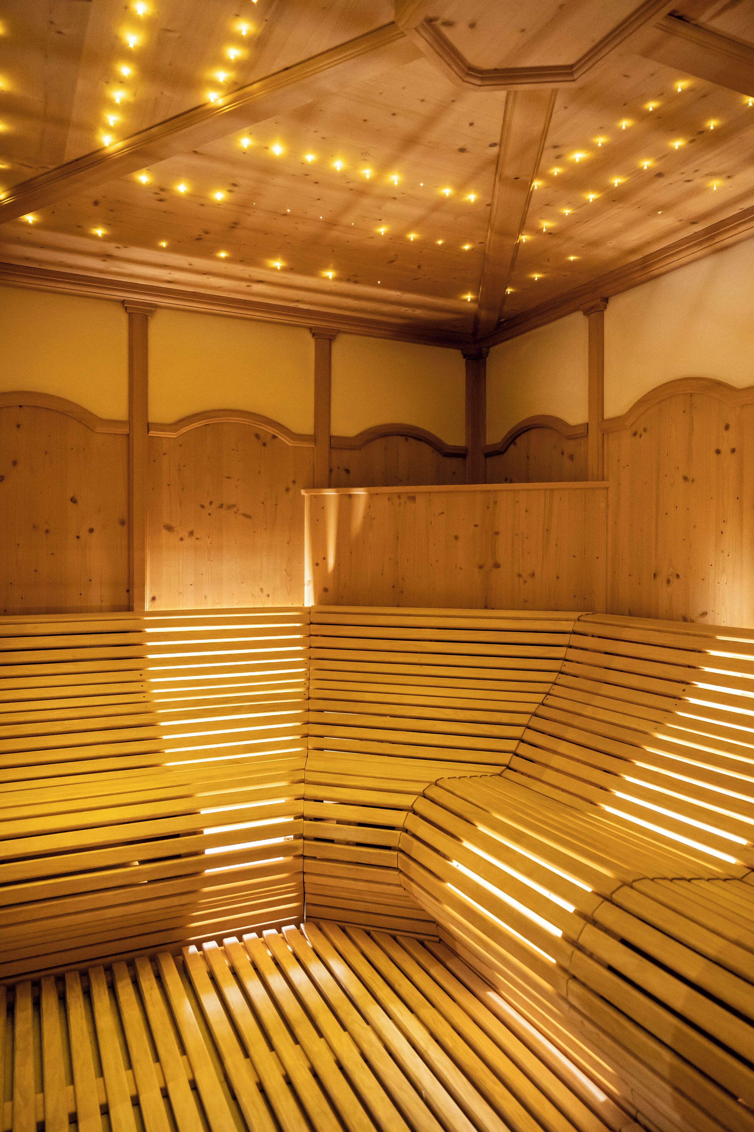 A sauna with wooden benches and a ceiling with lights.