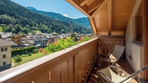 A wooden balcony with a view of a village and mountains. - Beverly Alps Hotel & Spa (Pinzolo)