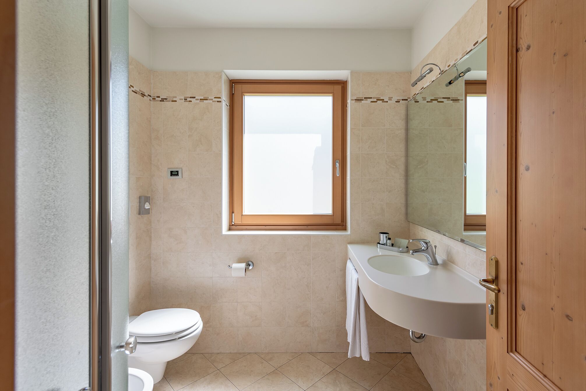 Un baño con inodoro, lavamanos y ventana.