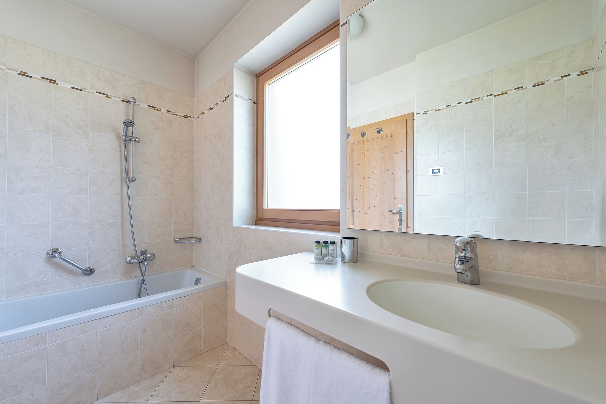 A modern bathroom with a bathtub, a sink, and a large mirror.