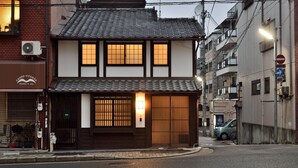 A traditional Japanese building with a tiled roof, a wooden entrance gate, and a sign for 'Casse-Croûte'. - Machiya Kamo River 7 (Kyoto)