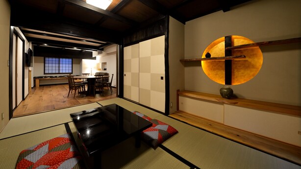 A traditional Japanese room with tatami flooring, a low table, and a sliding door. - Machiya Kamo River 7 (Kyoto)