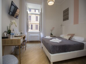 A modern hotel room with a bed, desk, and a television. - Al 7 Rooms (Rome)