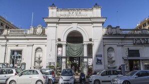 A building with a large archway labeled "SPQR Mercato Rioneale".