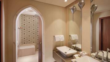 Une salle de bain moderne avec un grand miroir, deux lavabos et un espace douche.