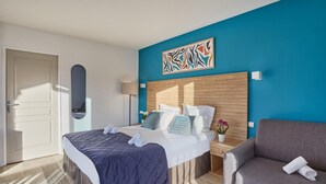 A hotel room with a bed, a sofa, a painting, and a door. - St Jean Luz Hotel Erromardie Suite 4p (Saint-Jean-de-Luz)