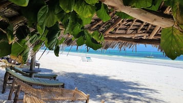 Playa privada, arena blanca, sillas reclinables de playa