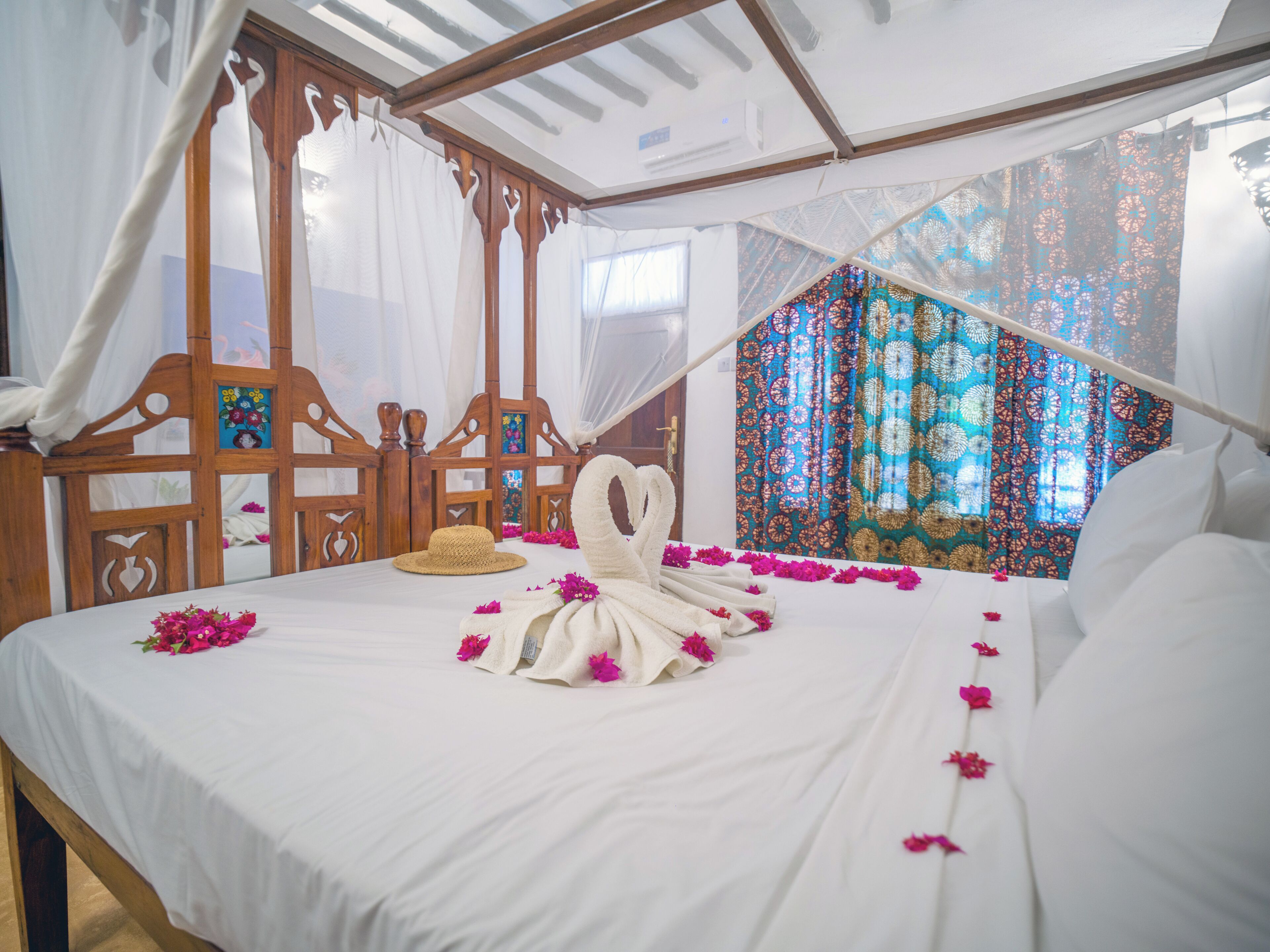 A bed with a canopy, a wooden headboard, and a decorative towel.