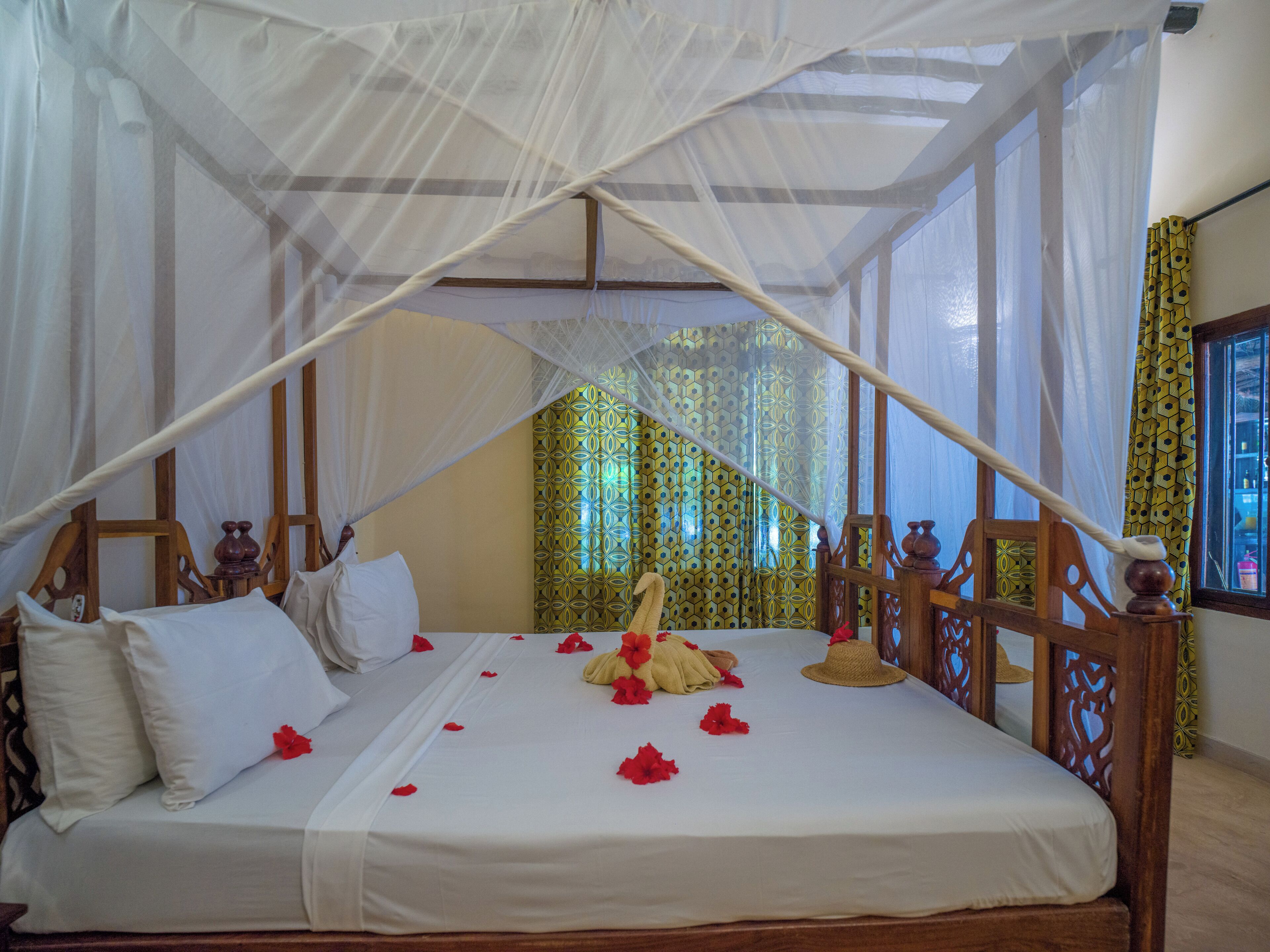 A bed with a canopy, pillows, and a decorative item on the bed.
