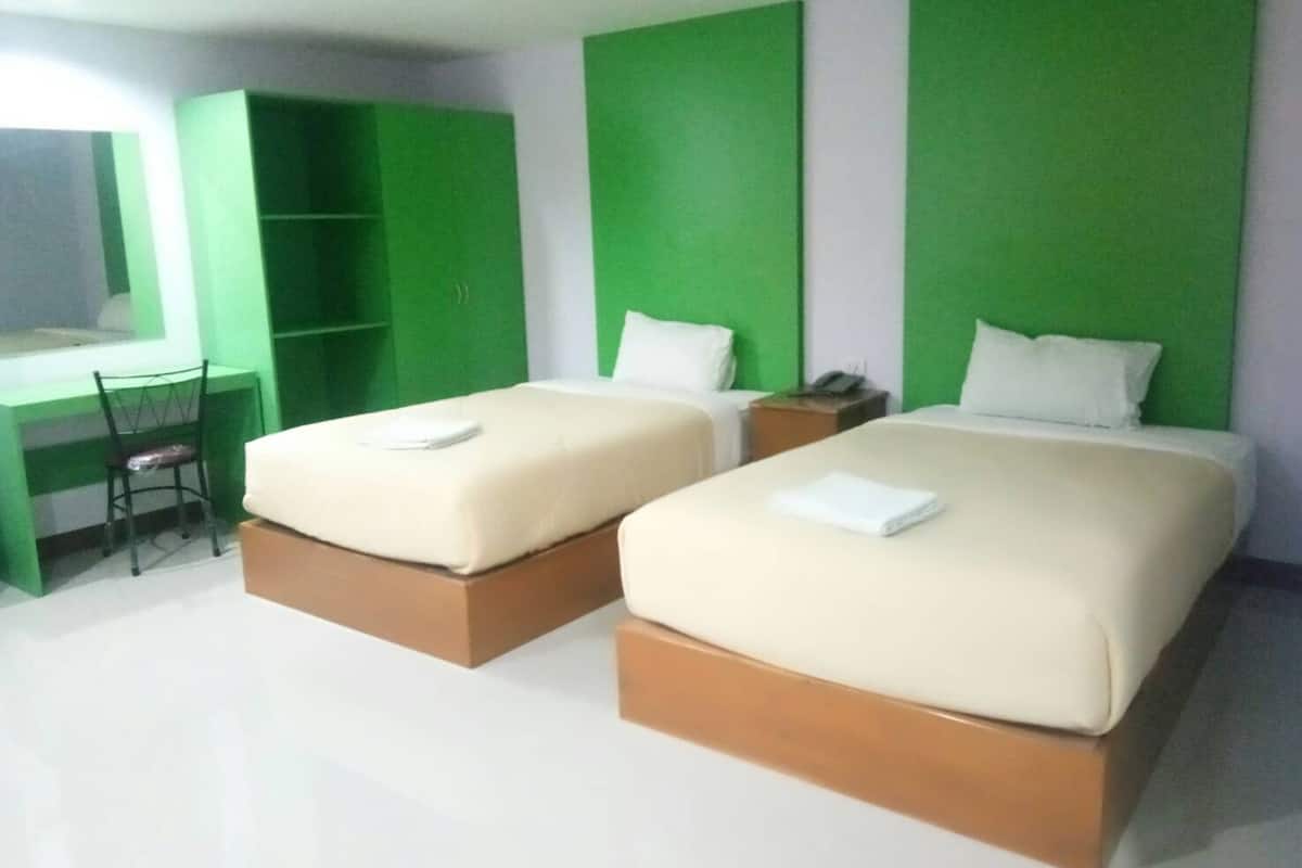 Een hotelkamer met twee bedden, een bureau en een stoel.