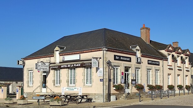 A building with signs for 'HOTEL DE LA PLACE' and 'PENSION'. There is a bench and a sign indicating '4 CHATEAUNEUF V/L'. - Hôtel de la place (Germigny-des-Pres)