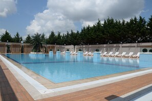 حمّام سباحة خارجي، مظلات على حمّام السباحة، مقاعد للتشمس