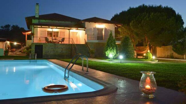 A house with a swimming pool, a well-lit patio, and a small garden area. - Villa Dimeon (West Achaea)