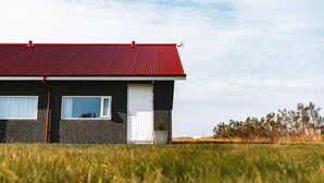 A two-story house with a red roof, white door, and windows. -  Hotel Snaefellsnes - formally Hotel Rjukandi (Eyja- og Miklaholtshreppur)