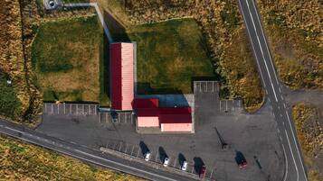Vista aérea de un estacionamiento con un edificio de techo rojo y una estructura de hormigón.