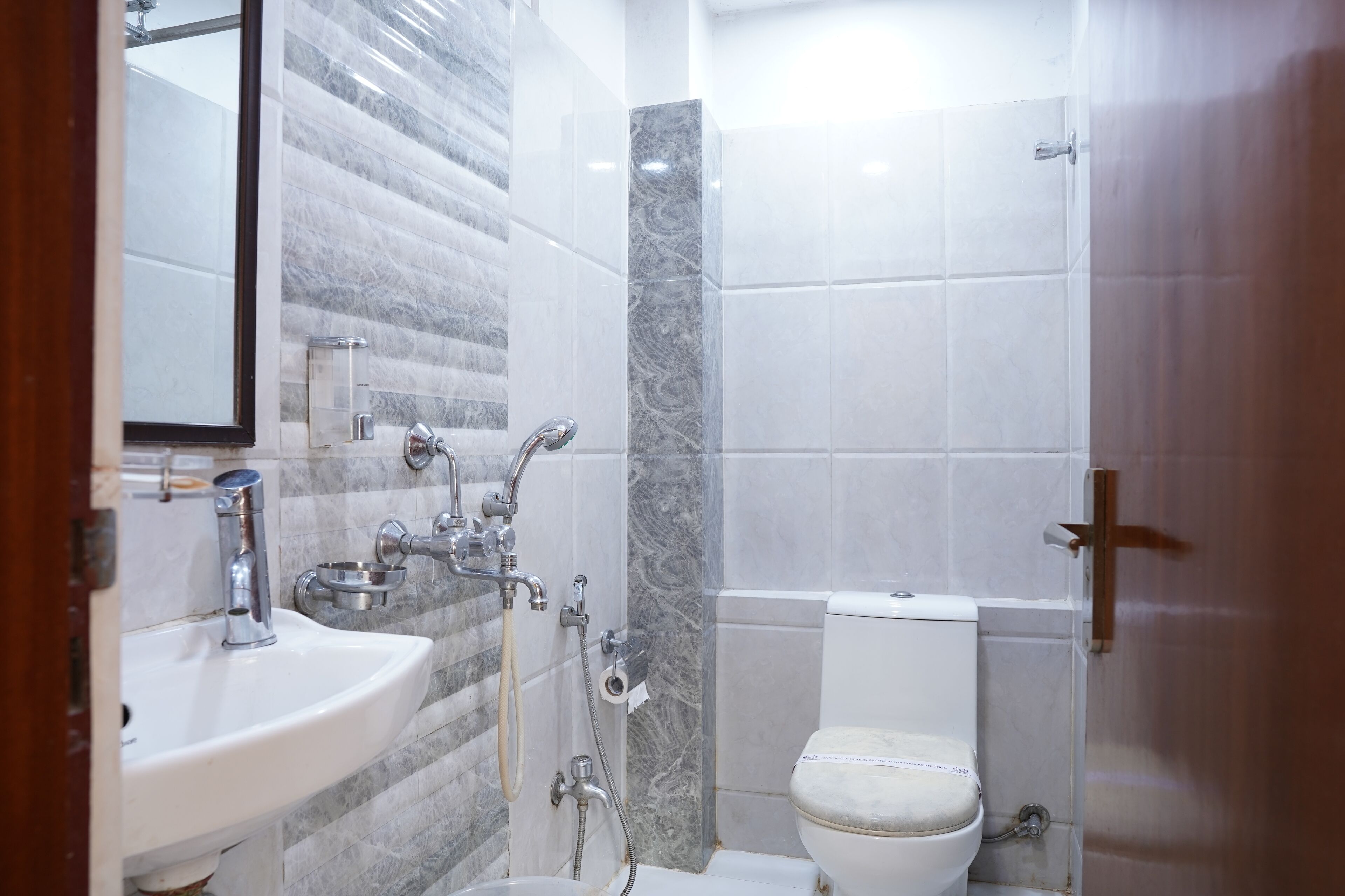 A modern bathroom with a sink, mirror, toilet, and shower.