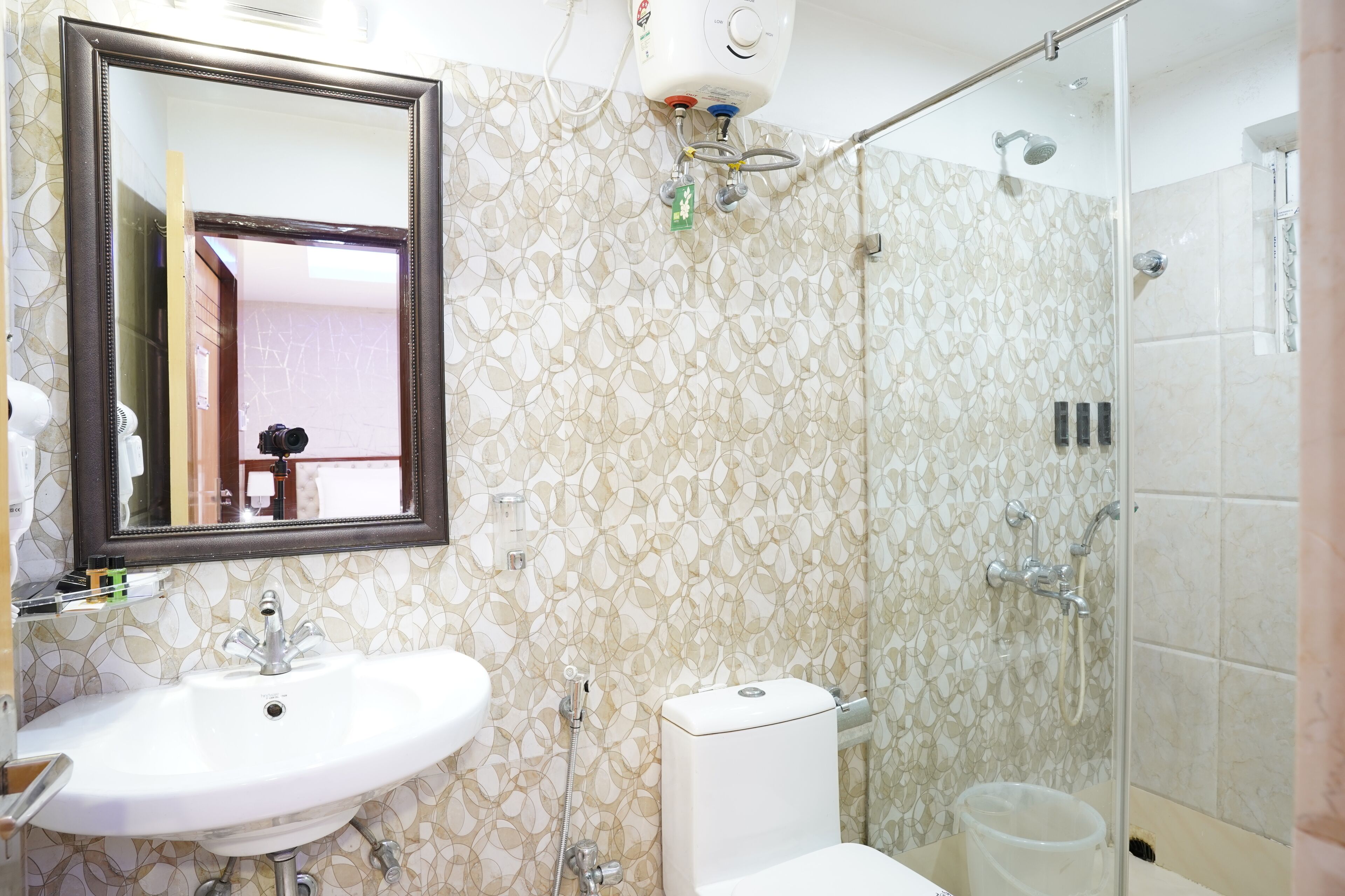 A bathroom with a white sink, a toilet, a shower with a glass door, and a mirror with a wooden frame.