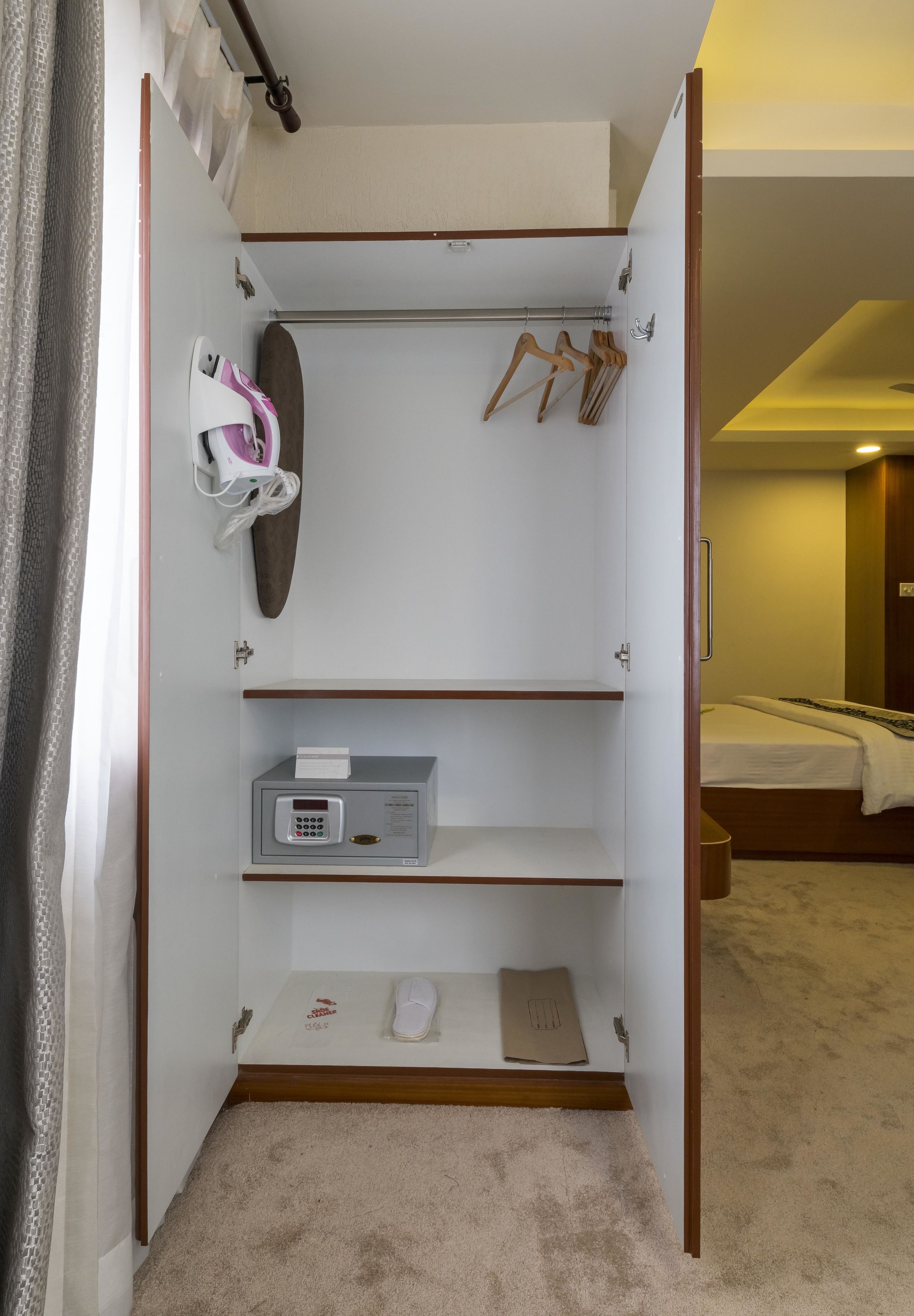 A walk-in closet with a shoe rack, a small heater, and a shoe shelf.