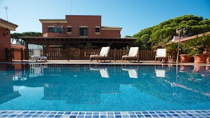 A clear blue pool with lounge chairs and a wooden fence. - Hotel Coral Playa (Chiclana de la Frontera)