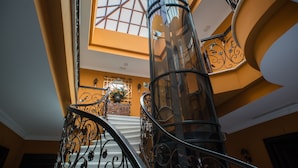 A spiral staircase with ornate metal railings and a skylight above. - Hotel Coral Playa (Chiclana de la Frontera)