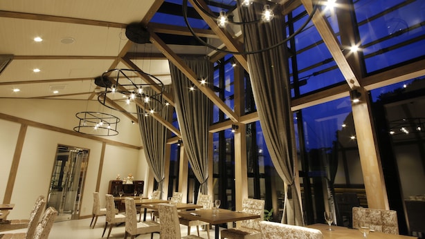 Un espace de restauration moderne doté de hauts plafonds, de grandes fenêtres et d’un éclairage contemporain.