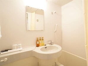 Een badkamer met een wastafel, spiegel en toiletartikelen.