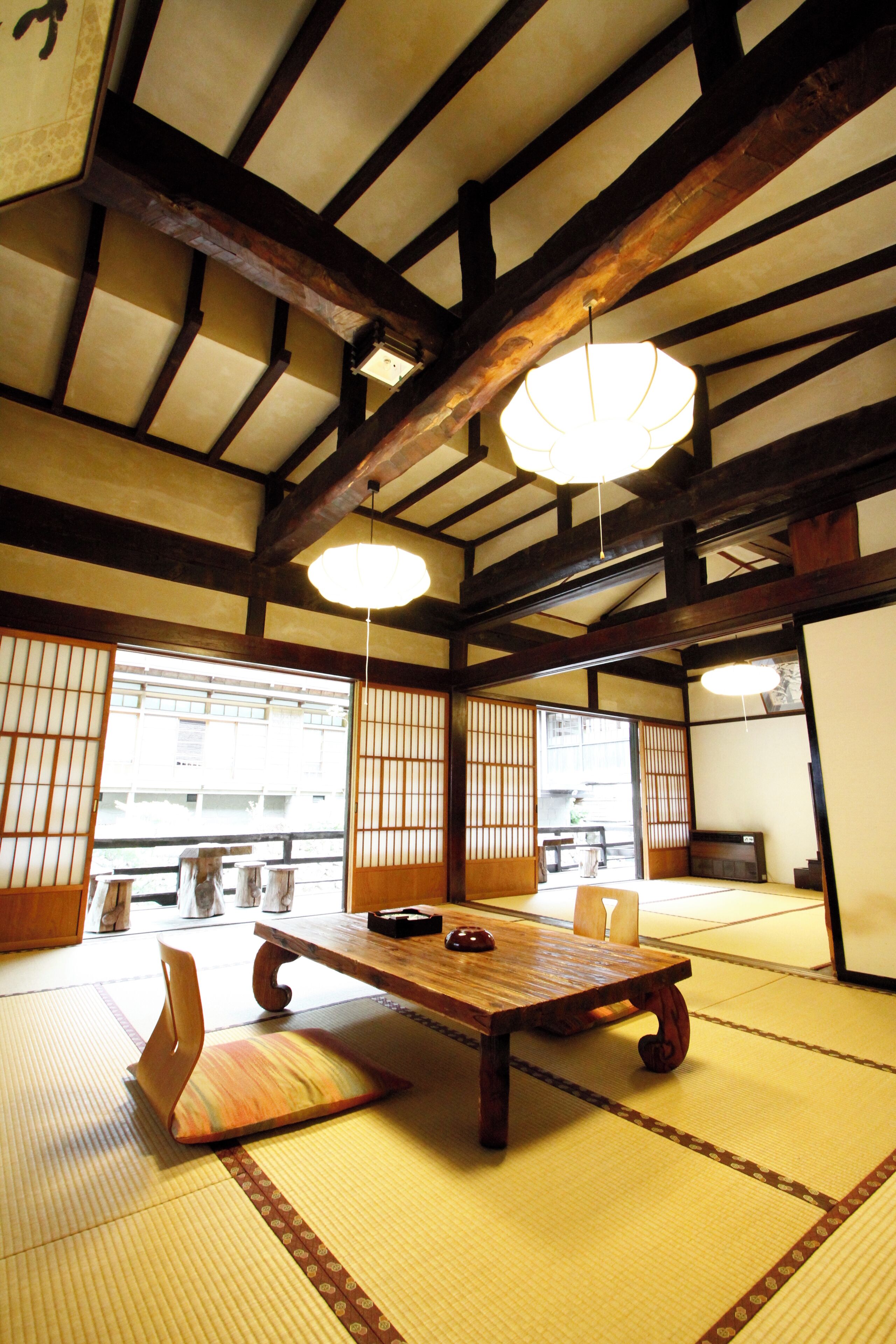 Una habitación japonesa tradicional con suelo de tatami, una mesa de madera baja y puertas correderas.