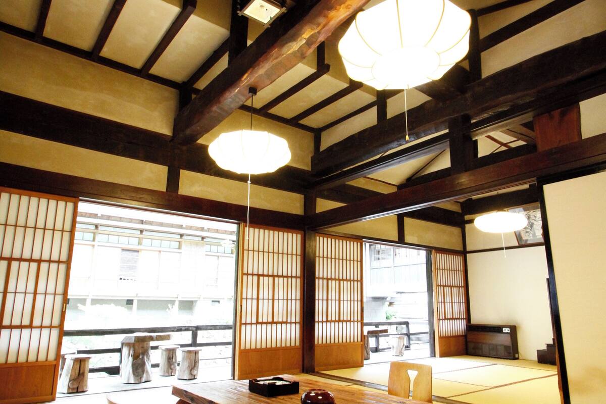A traditional Japanese room with tatami flooring, a low wooden table, and sliding doors.